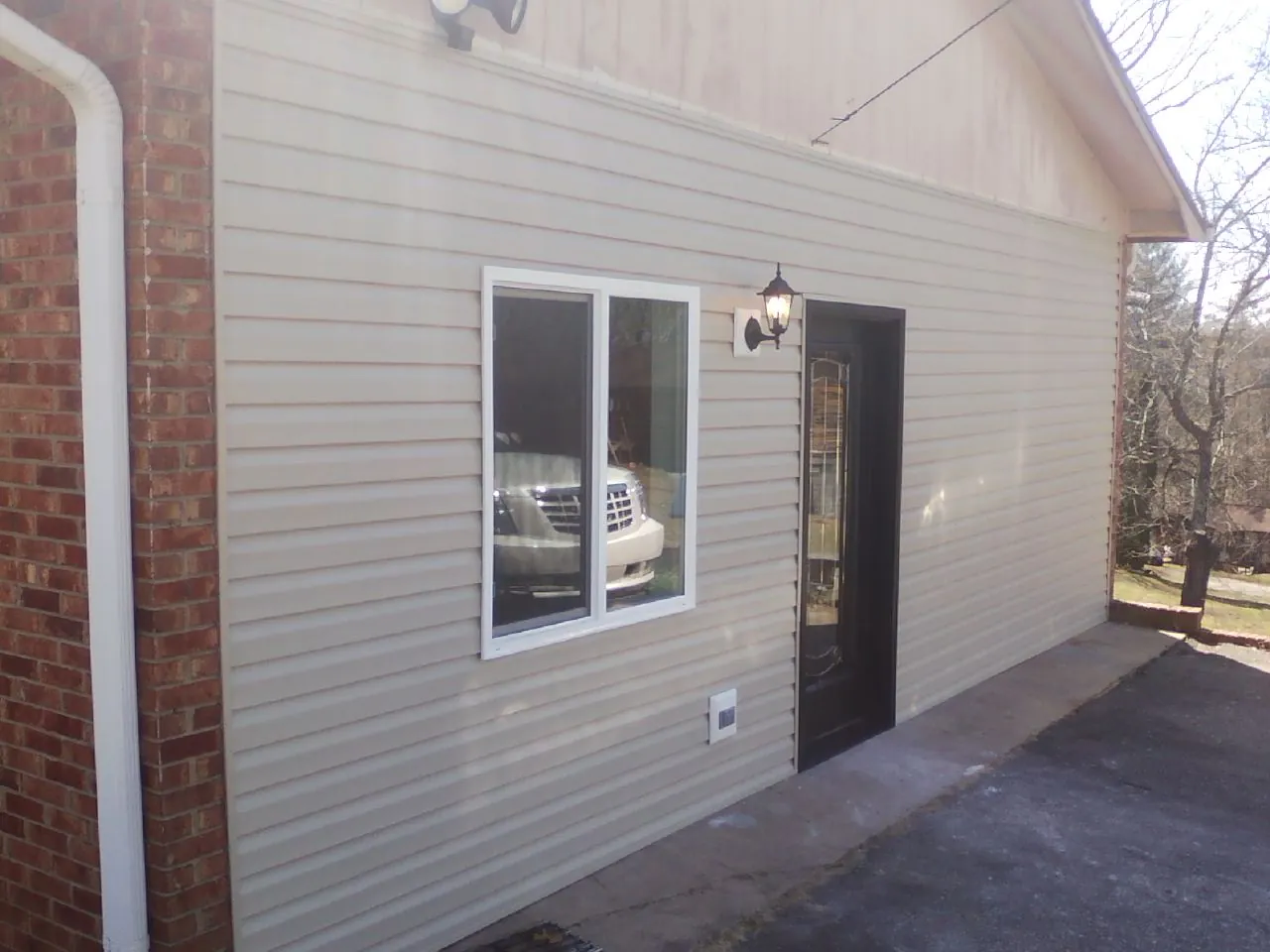 New vinyl siding and entry door on a room addition in Lafayette
